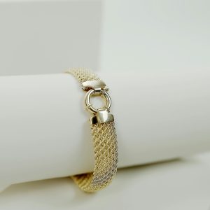 Luxurious gold bracelet with a stylish design on a white surface.